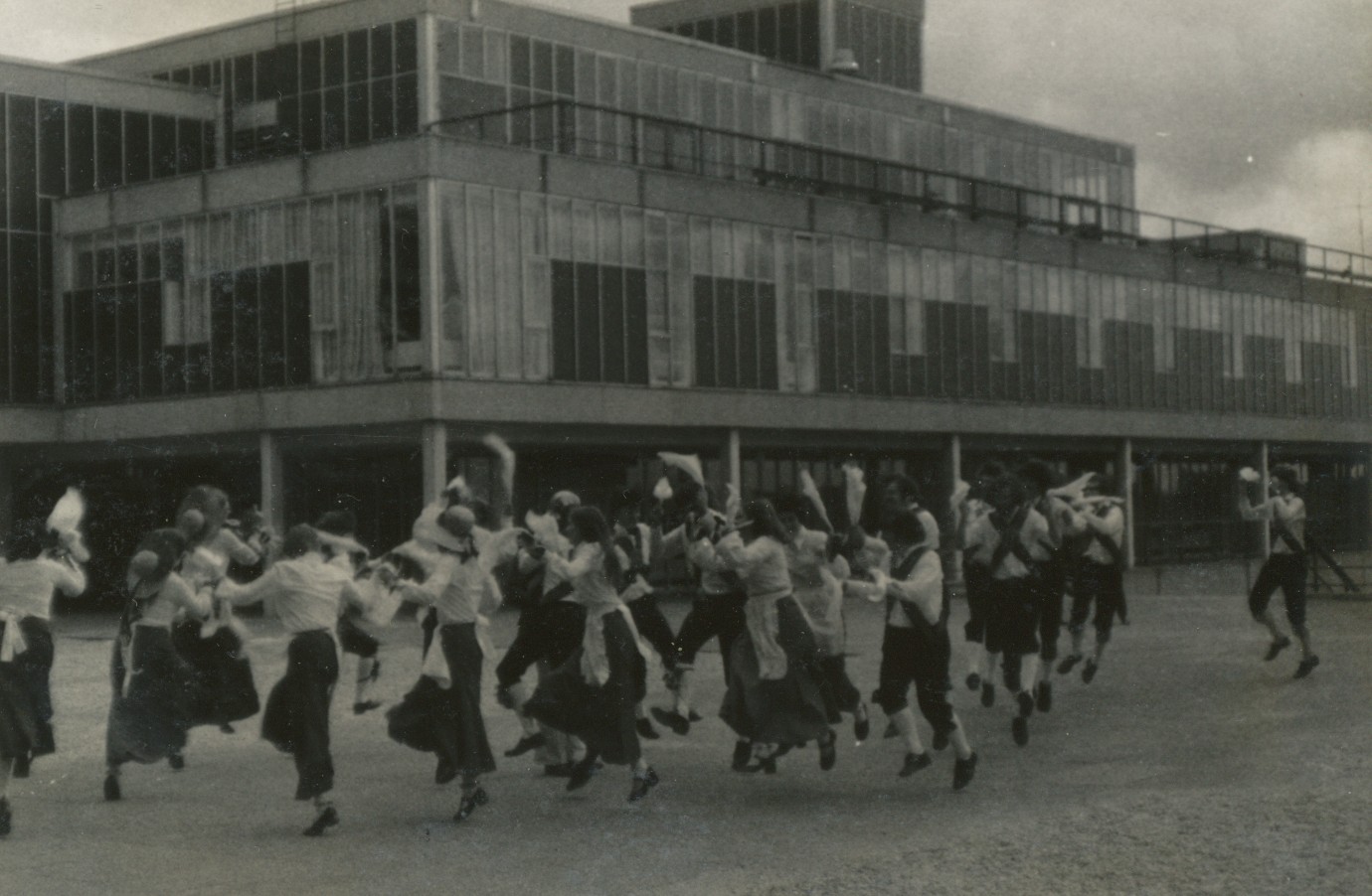 Black and white image showing Morris dancers dancing on the Central Parade, Claverton Down campus, University of Bath
